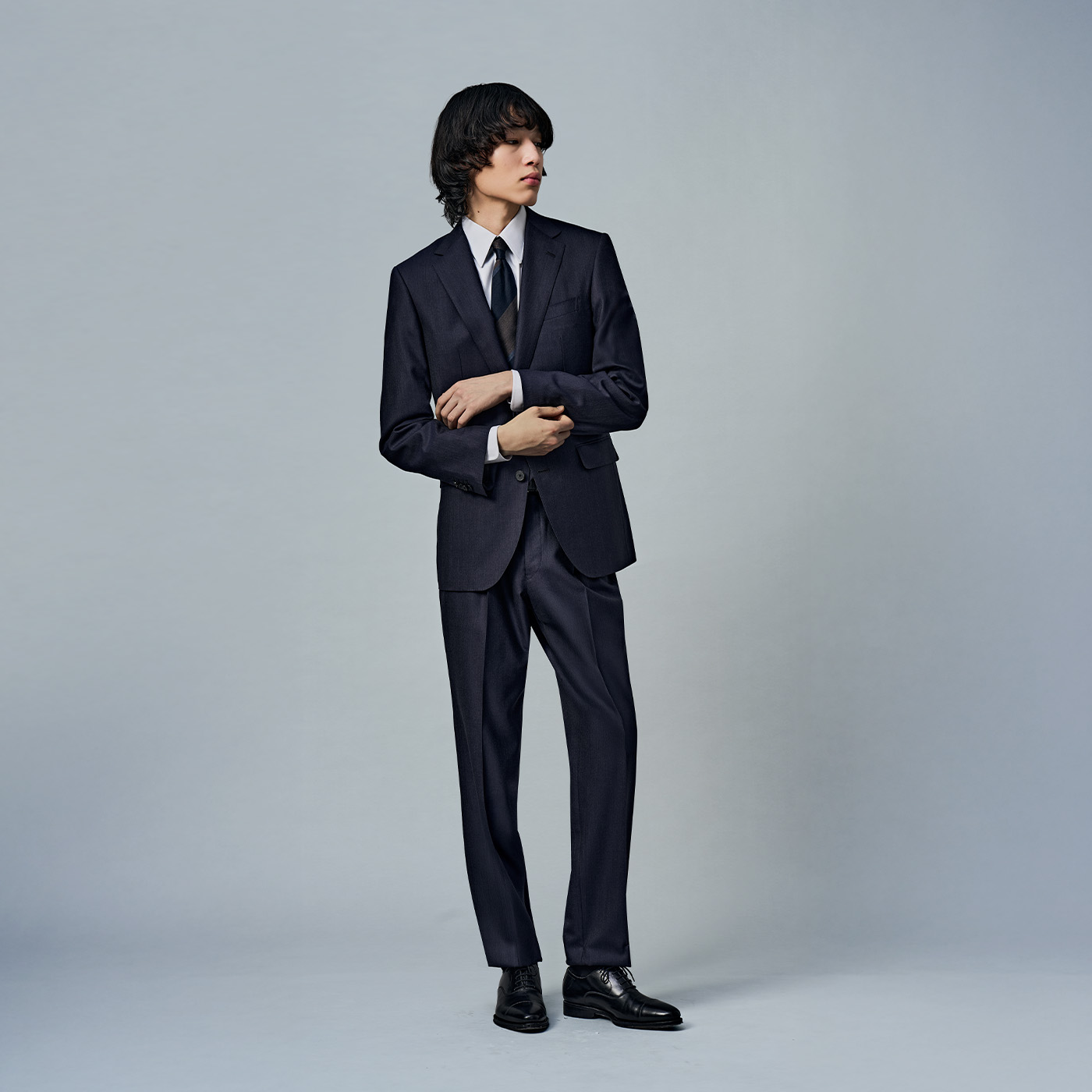 春らしいニュアンスカラーを生かしたネイビースーツスタイル